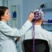 Back View Man Patient Wearing Performant Brainwave Scanning Headset Sitting Neurological Research Laboratory While Medical Researcher Adjusting It Examining Nervous System Typing Tablet 2